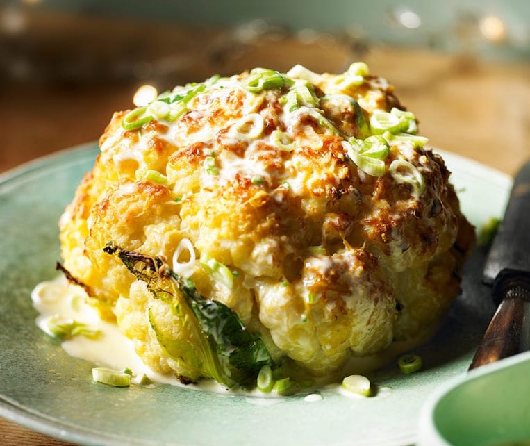 Whole roasted cauliflower with cheddar and spring onion sauce